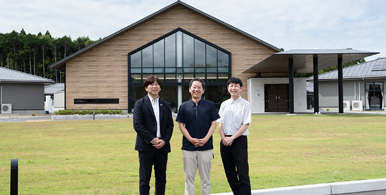 しせつのたてもののまえに、ざだんかいのとうだんしゃ3にんがならんでいる